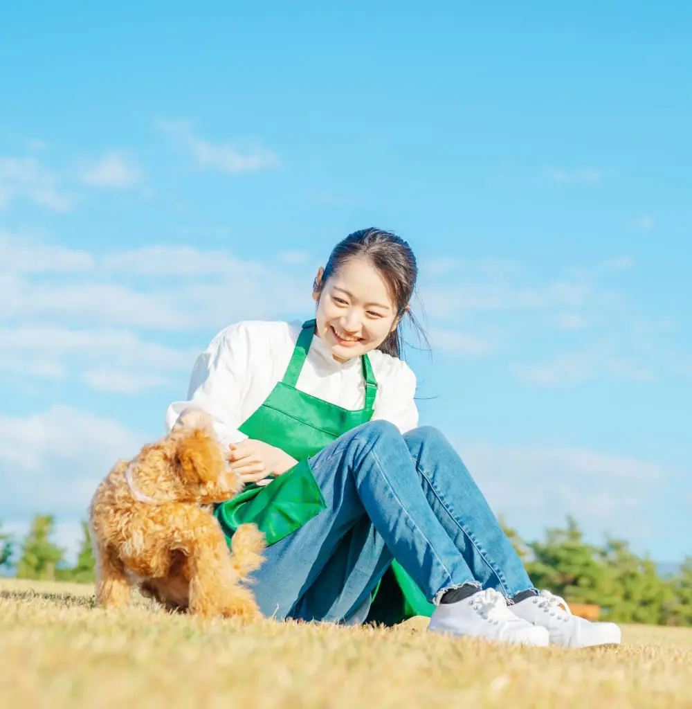 外で犬と遊ぶ女性